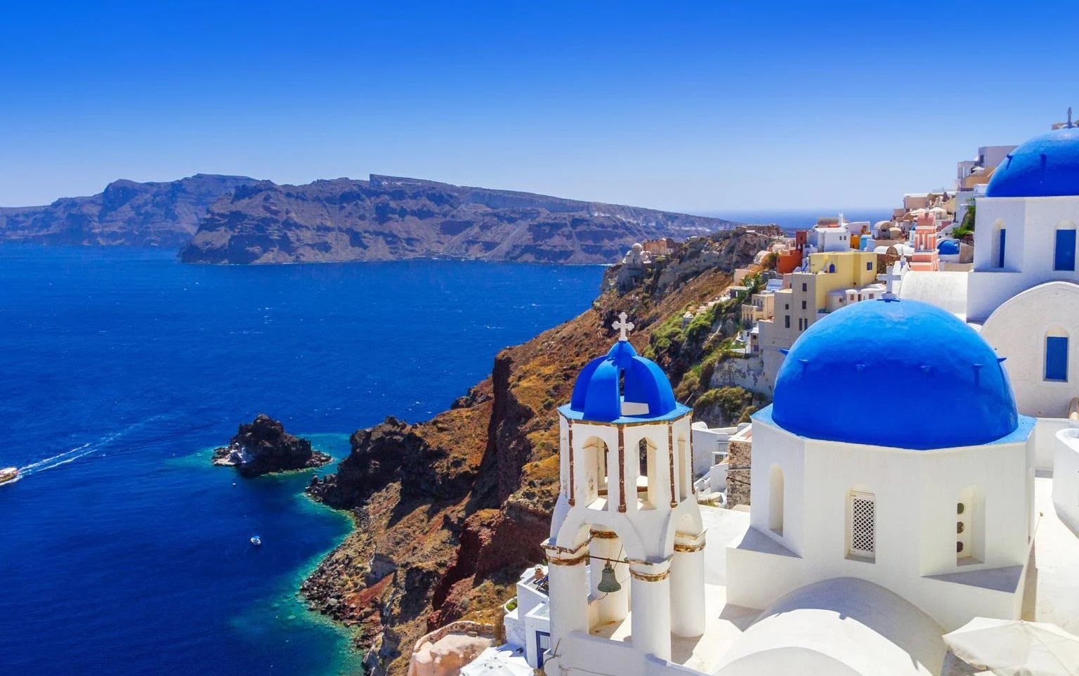 Whitewashed houses and blue domes above the Aegean Sea